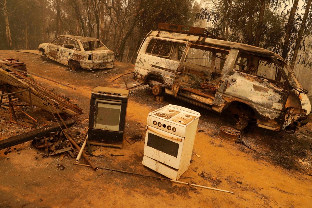 Burnt vehicles are seen at an area affected by a forest fire in Santa Juana, Concepcion province, Chile on February 5, 2023. (Photo by JAVIER TORRES / AFP)