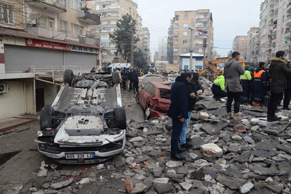 People search for survivors through the rubble in Diyarbakir, on February 6, 2023, after a 7.8-magnitude earthquake struck the country's south-east. Photo by ILYAS AKENGIN / AFP
