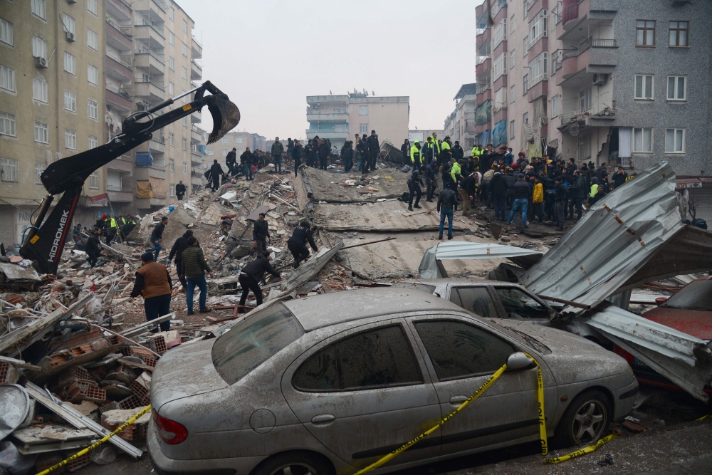 People search for survivors in Diyarbakir, Turkey, on February 6, 2023, after a 7.8-magnitude earthquake struck the country's south-east. (Photo by ILYAS AKENGIN / AFP)