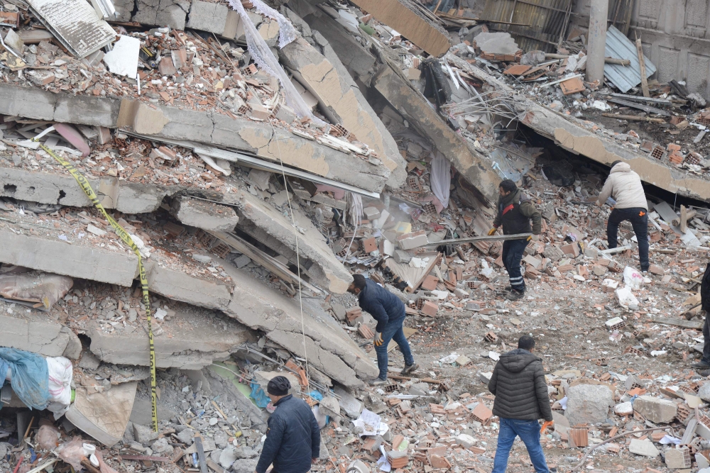 Rescue workers and volunteers conduct search and rescue operations in the rubble of a collasped building, in Diyarbakir on February 6, 2023, after a 7.8-magnitude earthquake struck the country's south-east. (Photo by ILYAS AKENGIN / AFP)