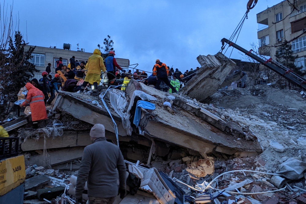 Rescue workers and volunteers search for survivors in the rubble of a collapsed building, in Sanliurfa, Turkey, on February 6, 2023, after a 7.8-magnitude earthquake struck the country's southeast. (Photo by REMI BANET / AFP)