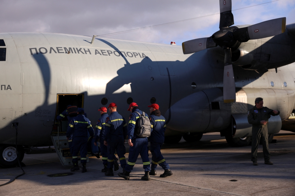 Members of the Disaster Response Special Unit who will fly to Turkey to help in the aftermath of an earthquake, board a Hellenic Air Force C-130, before departing from the military airport of Elefsina, Greece, February 6, 2023. (REUTERS/Louiza Vradi)