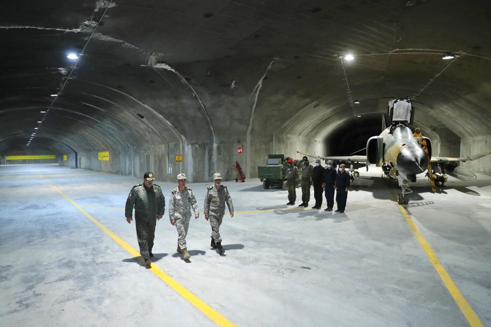 A handout picture provided by the Iranian Army office on February 7, 2023 shows Commander-in-Chief of the Iranian Army Major General Abdolrahim Mousavi (right) and Armed Forces Chief of Staff Major General Mohammad Bagheri (centre) visiting Iran's first underground military air base in an undisclosed location. (Photo by Iranian Army office / AFP) 
