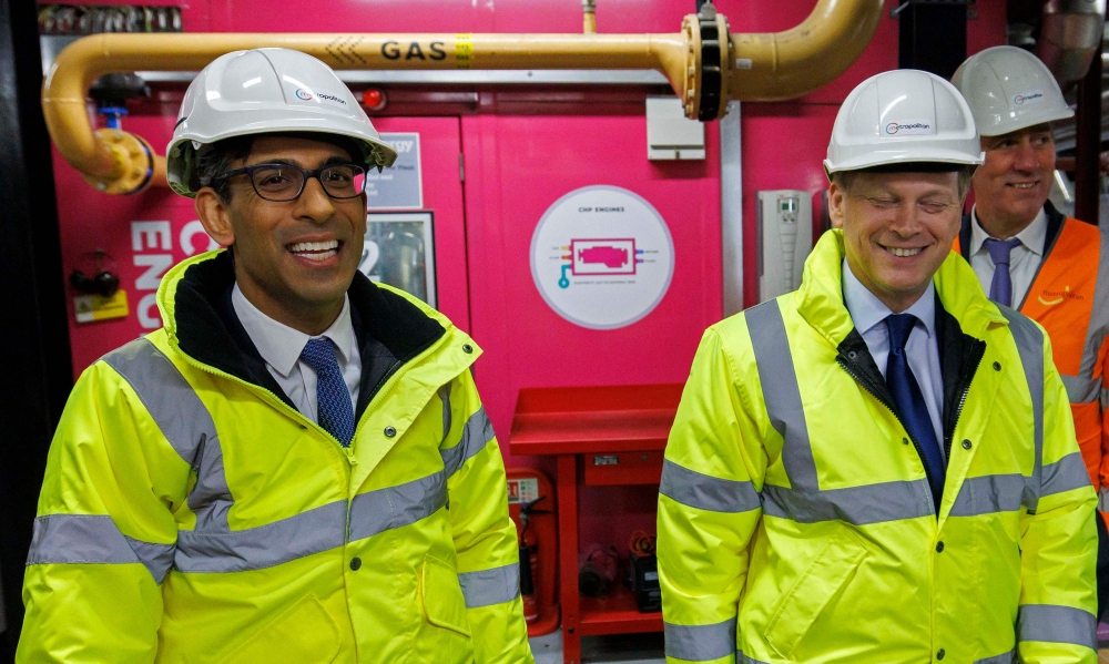 Britain's Prime Minister Rishi Sunak (left) and Britain's Secretary of State for Energy Security and Net Zero Grant Shapps as they tour the Combined Heat and Power Plant (CHP) at King's Cross in London on February 7, 2023. (Photo by Jamie Lorriman / POOL / AFP)