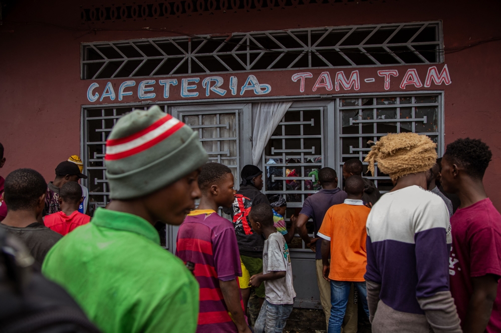 Demonstrators gather before attacking a cafe allegedly run by Rwandophone Banyamulenge, during a demonstration against the East Africa Community Regional Force in Goma on February 6, 2023 during which protesters erected barricades, torched tyres and where some shops were looted. - Thousands of people demonstrated Monday in Goma, the commercial hub in eastern DR Congo, to protest the perceived inaction of an East African military force against the M23 rebel insurgency. (Photo by AFP)