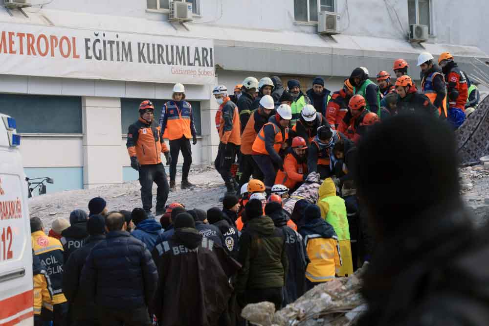 Rescuers evacuate a victim retrieved in the rubble of collapsed buldings in Gaziantep, close to the quake's epicentre, a day after a 7.8-magnitude earthquake struck the country's southeast, on February 7, 2023.  (Photo by Zein Al RIFAI / AFP)
 