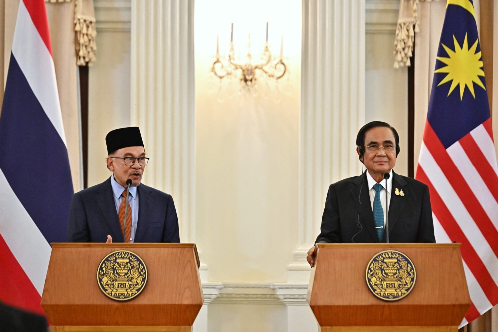 Malaysia's Prime Minister Anwar Ibrahim (left) and Thailand's Prime Minister Prayut Chan-O-Cha attend a joint press conference during an official state visit at Government House in Bangkok on February 9, 2023. (Photo by Lillian SUWANRUMPHA / AFP)