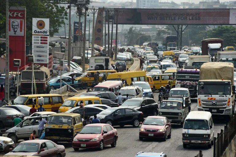 Drivers wait in line to buy fuel at and next to a filling station, causing traffic gridlock on Lagos' Ibadan expressway, in Lagos on January 30, 2023. Nigerian drivers spend hours in traffic gridlocks less than a month prior to the presidential election [Pius Utomi Ekpei/AFP]
