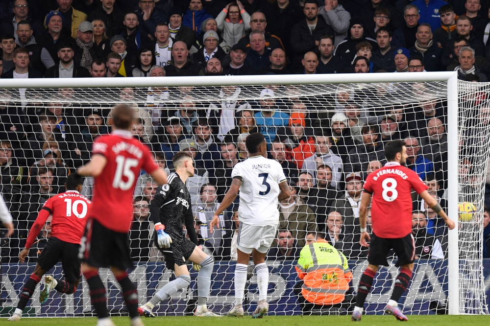 Manchester United's English striker Marcus Rashford (left) scores the opening goal of the English Premier League match between Leeds United and Manchester United at Elland Road in Leeds, northern England on February 12, 2023. (Photo by Oli SCARFF / AFP)