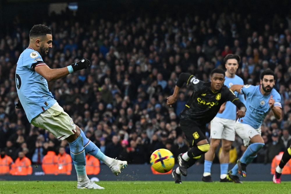 Manchester City's Algerian midfielder Riyad Mahrez scores their third goal from the penalty spot during the English Premier League match between Manchester City and Aston Villa at the Etihad Stadium in Manchester, north west England, on February 12, 2023. (Photo by Paul ELLIS / AFP)