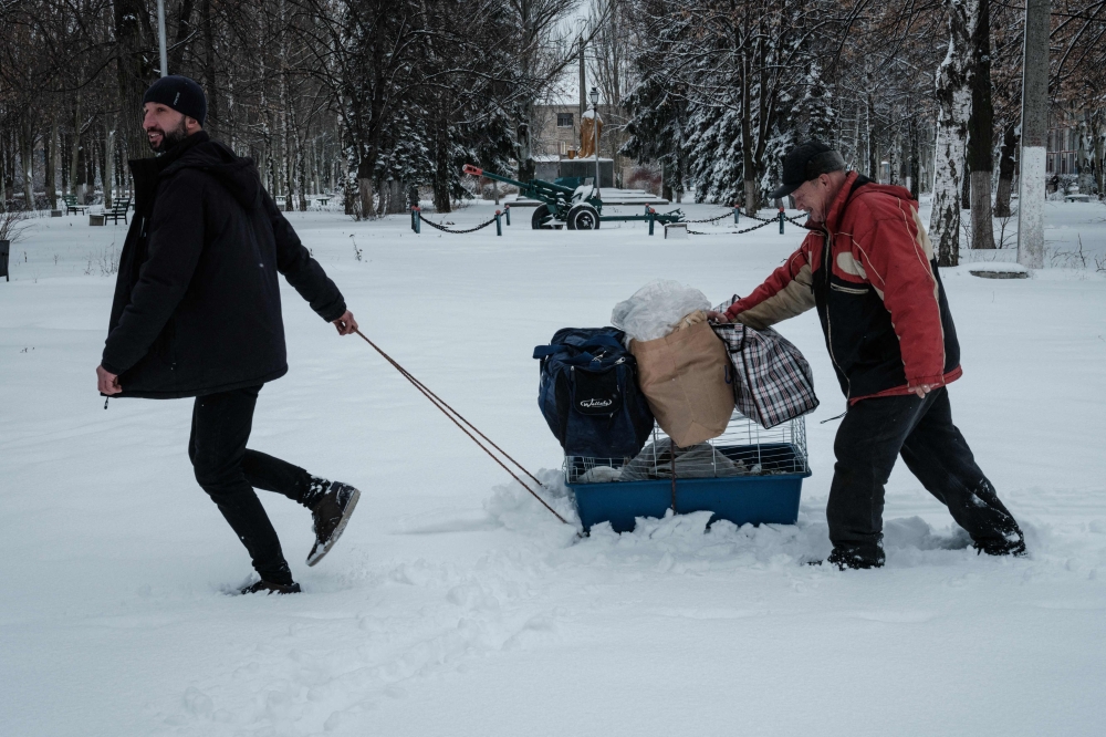 Residents put their belongings on top of a cage containing a rabit as they evacuate Chasiv Yar on February 14, 2023, amid the Russian invasion of Ukraine. (Photo by YASUYOSHI CHIBA / AFP)