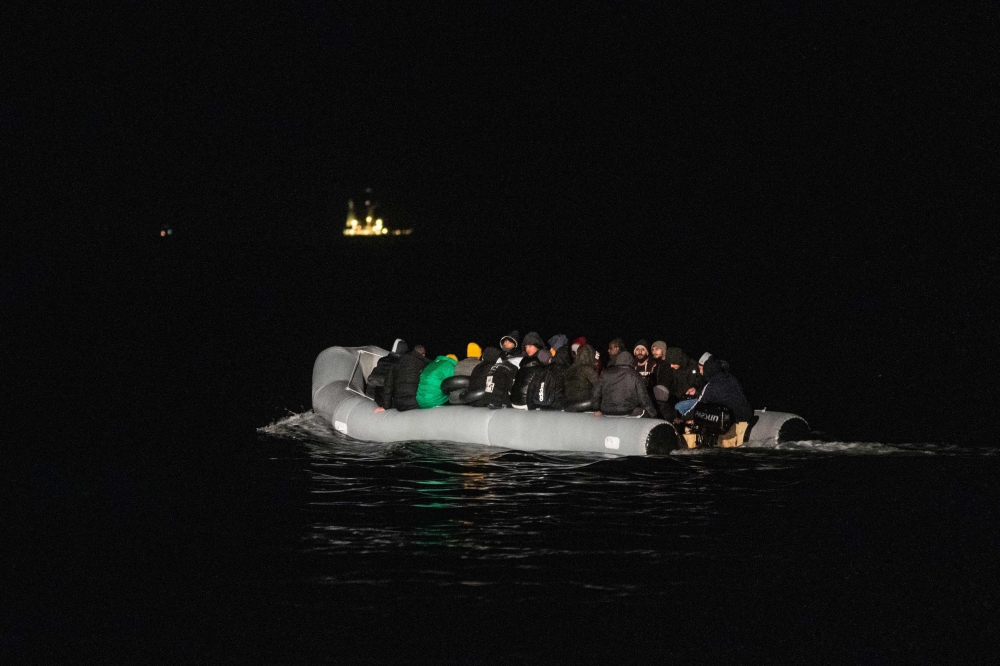 (FILES) In this file photo taken on March 15, 2022 migrants sits in a dinghy illegally crossing the English Channel from France to Britain. (Photo by Sameer Al-DOUMY / AFP)