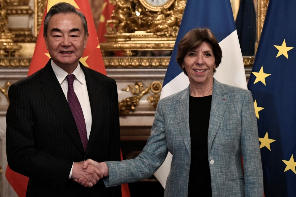 China's Foreign minister Wang Yi shakes hands with French Foreign and European Affairs Minister Catherine Colonna ahead of their meeting in Paris, on February 15, 2023. (Photo by STEPHANE DE SAKUTIN / AFP)