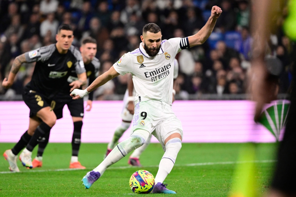 Real Madrid's French forward Karim Benzema takes a penalty kick and scores his team's third goal during the Spanish League match between Real Madrid CF and Elche CF at the Santiago Bernabeu stadium in Madrid on February 15, 2023. (Photo by JAVIER SORIANO / AFP)