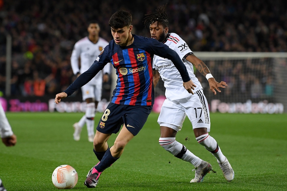 Barcelona's Spanish midfielder Pedri (left) fights for the ball with Manchester United's Brazilian midfielder Fred during the UEFA Europa League round of 32 first-leg match between FC Barcelona and Manchester United at the Camp Nou stadium in Barcelona, on February 16, 2023. (Photo by Josep LAGO / AFP)
