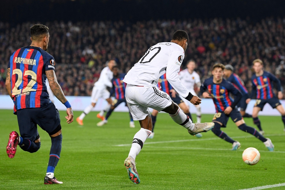 Rashford kicks the ball before Barcelona's French defender Jules Kounde scores an own goal during the UEFA Europa League round of 32 first-leg football match between FC Barcelona and Manchester United at the Camp Nou stadium in Barcelona, on February 16, 2023. (Photo by Josep LAGO / AFP)
