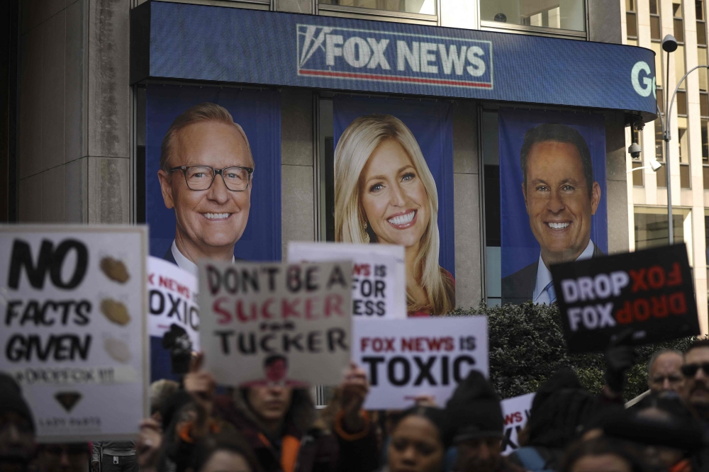 (FILES) In this file photo taken on March 13, 2019 protesters rally against Fox News outside the Fox News headquarters at the News Corporation building in New York City. - Media titan Rupert Murdoch described Donald Trump's claims that the 2020 election was stolen as 