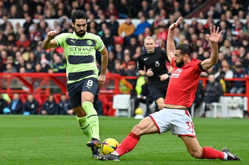 Manchester City's German midfielder Ilkay Gundogan (L) fights for the ball with Nottingham Forest's Brazilian defender Felipe during the English Premier League match between Nottingham Forest and Manchester City at The City Ground in Nottingham, central England, on February 18, 2023. (Photo by JUSTIN TALLIS / AFP)