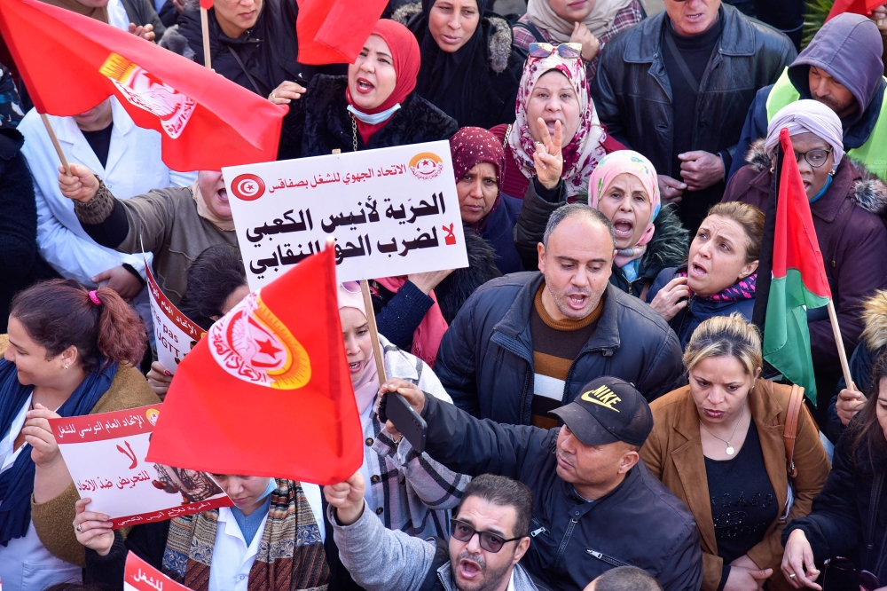 Protesters chant slogans during a demonstration called by the General Union of Tunisian Workers (UGTT) over worsening economic woes and the arrest of a top union official, in Tunisia's second city of Sfax, on February 18, 2023. (Photo by IMED HADDAD / AFP)