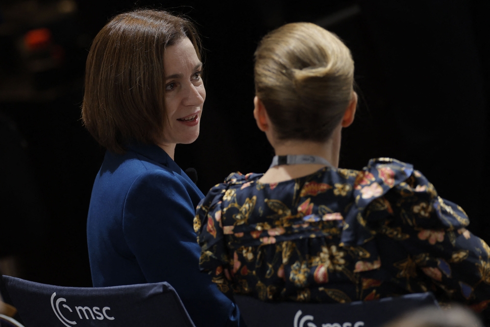 Moldova's President Maia Sandu (left) and Denmark's Prime Minister Mette Frederiksen talk as they attend the Munich Security Conference in Munich, southern Germany, on February 18, 2023. (Photo by Odd Andersen / AFP)
