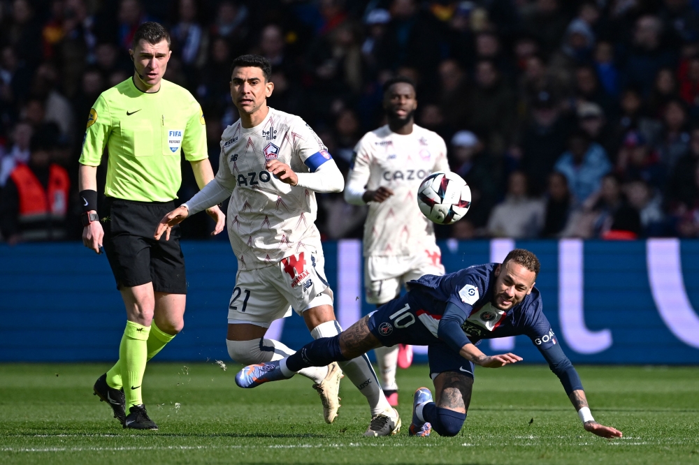 Paris Saint-Germain's Brazilian forward Neymar (right) falls, injured after a contact with Lille's French midfielder Benjamin Andre (centre) during the French L1 match between Paris Saint-Germain (PSG) and Lille LOSC at The Parc des Princes Stadium in Paris on February 19, 2023. (Photo by Anne-Christine POUJOULAT / AFP)