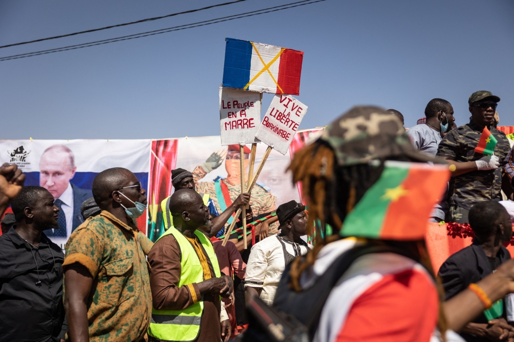 A demonstrator holds placards during a protest to support Burkina Faso President Captain Ibrahim Traore and to demand the departure of France's ambassador and military forces, in Ouagadougou, on January 20, 2023. (Photo by OLYMPIA DE MAISMONT / AFP)