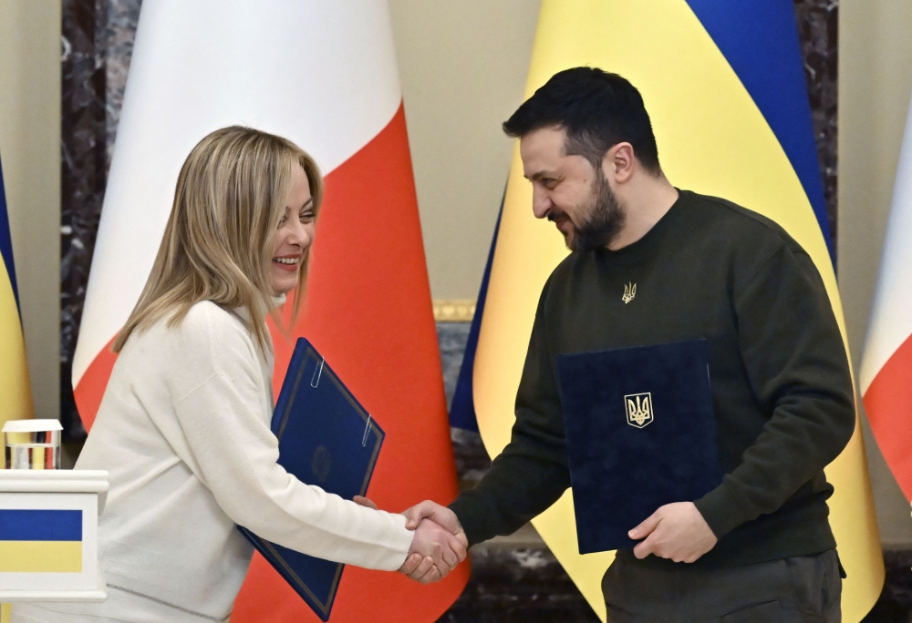 Ukrainian President Volodymyr Zelensky and Italian Prime Minister Giorgia Meloni shake hands before a joint press conference after their meeting in Kyiv on February 21, 2023. (Photo by Genya Savilov / AFP)