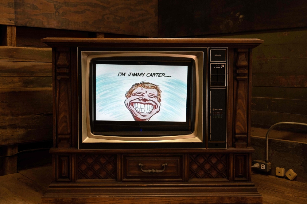 A video celebrates the life of former US President Jimmy Carter at The Plains Depot, where the former politician headquartered his presidential campaign, in the Jimmy Carter National Historical Park in Plains, Georgia, on February 20, 2023. (Photo by Brendan Smialowski / AFP)