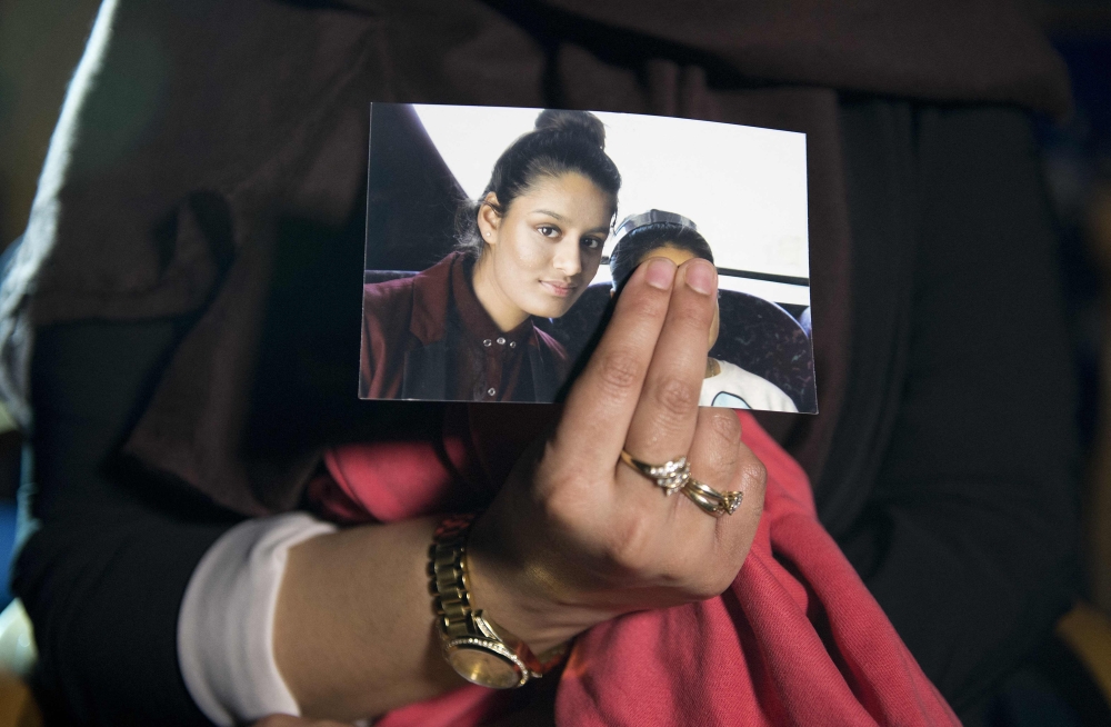 In this file photo taken on February 22, 2015 Renu, eldest sister of missing British girl Shamima Begum, holds a picture of her sister Shamima, while being interviewed by the media in central London. (Photo by Laura Lean / AFP)