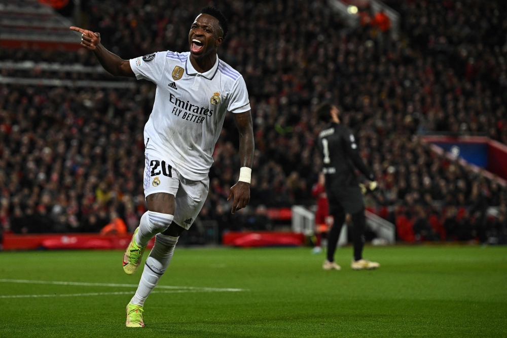 Liverpool's Brazilian goalkeeper Alisson Becker reacts as Real Madrid's Brazilian forward Vinicius Junior celebrates scoring the team's second goal during the UEFA Champions League last 16 first leg football match between Liverpool and Real Madrid at Anfield in Liverpool, north west England on February 21, 2023. (Photo by Paul ELLIS / AFP)
