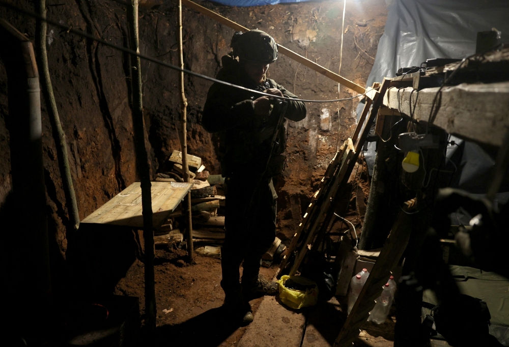 A Ukrainian soldier stands in a dugout on the front line near Bakhmut, Donetsk region on February 21, 2023, amid Russian invasion of Ukraine. (Photo by Anatolii Stepanov / AFP)
 