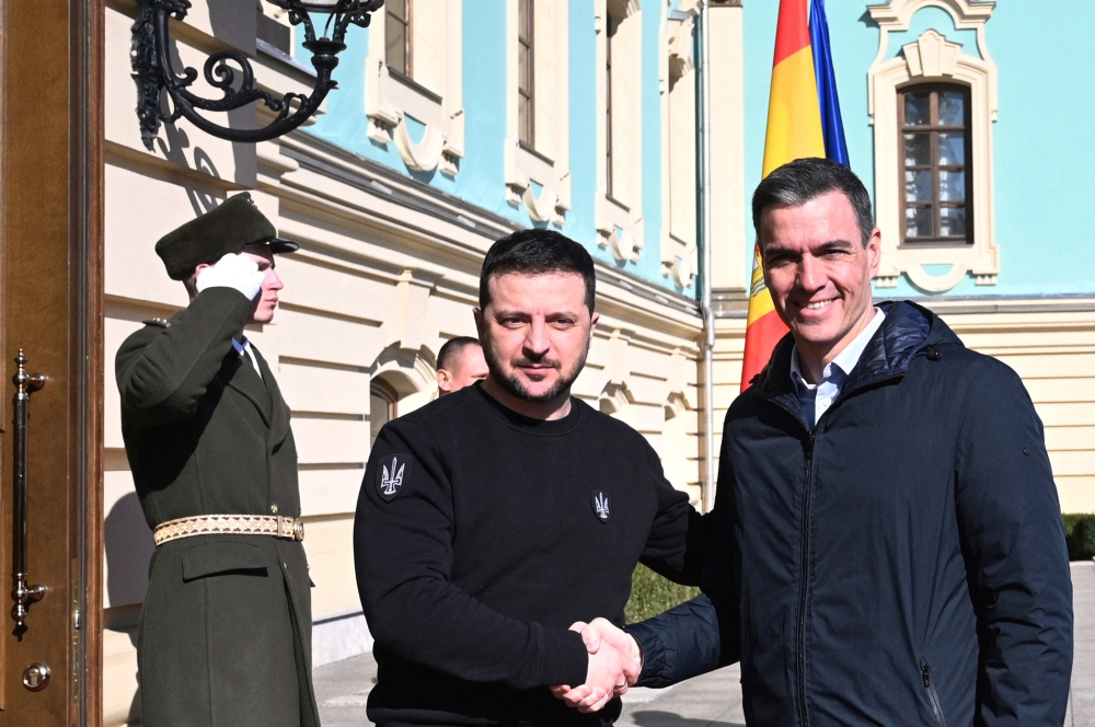 In this handout image released by La Moncloa on February 23, 2023 Spanish Prime Minister Pedro Sanchez shakes hands with Ukrainian President Volodymyr Zelensky, during his visit to Kiev, in Ukraine.  (Photo by Borja Puig de la BELLACASA / LA MONCLOA / AFP) 