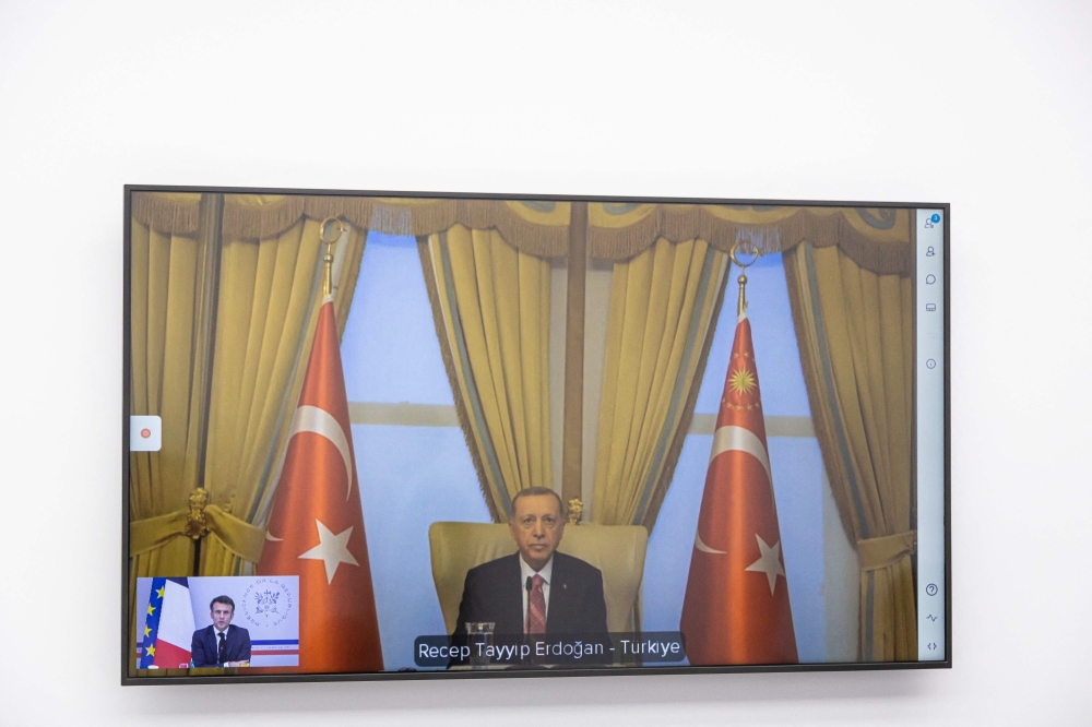 Turkish President Recep Tayyip Erdogan is seen on screen as he holds an online meeting with French President Emmanuel Macron, at the Elysee Palace in Paris on February 24, 2023. (Photo by Christophe PETIT TESSON / POOL / AFP)

