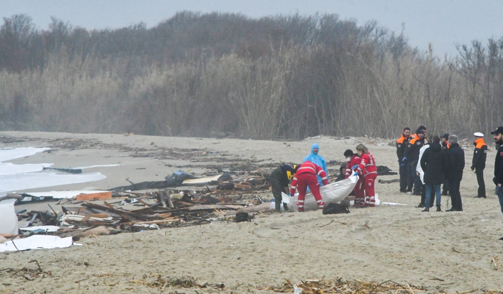 Photo obtained from Italian news agency Ansa, taken on February 26, 2023 shows rescuers handling a body bag at the site of a shipwreck in Steccato di Cutro, south of Crotone, after a migrants' boat sank off Italy's southern Calabria region. - More than 30 migrants, including a tiny baby, died after their overloaded boat sank early on February 26, 2023 in stormy seas off Italy's southern Calabria region, Italian media and rescue services reported. (Photo by STRINGER / ANSA / AFP)