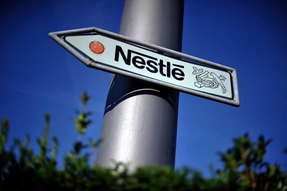 This file photo taken on August 10, 2011 shows Nestle's logo on a road sign near the company's headquarters in Vevey, Switzerland. (Photo by Fabrice Coffrini / AFP)