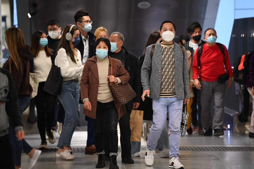 People wear masks on the Mass Transit Railway (MTR) system in Hong Kong on February 27, 2023 as health experts in the territory backed the extension of its mask mandate to March 8 leaving Hong Kong as one of the only places left in the world with such rules. (Photo by Peter Parks / AFP)