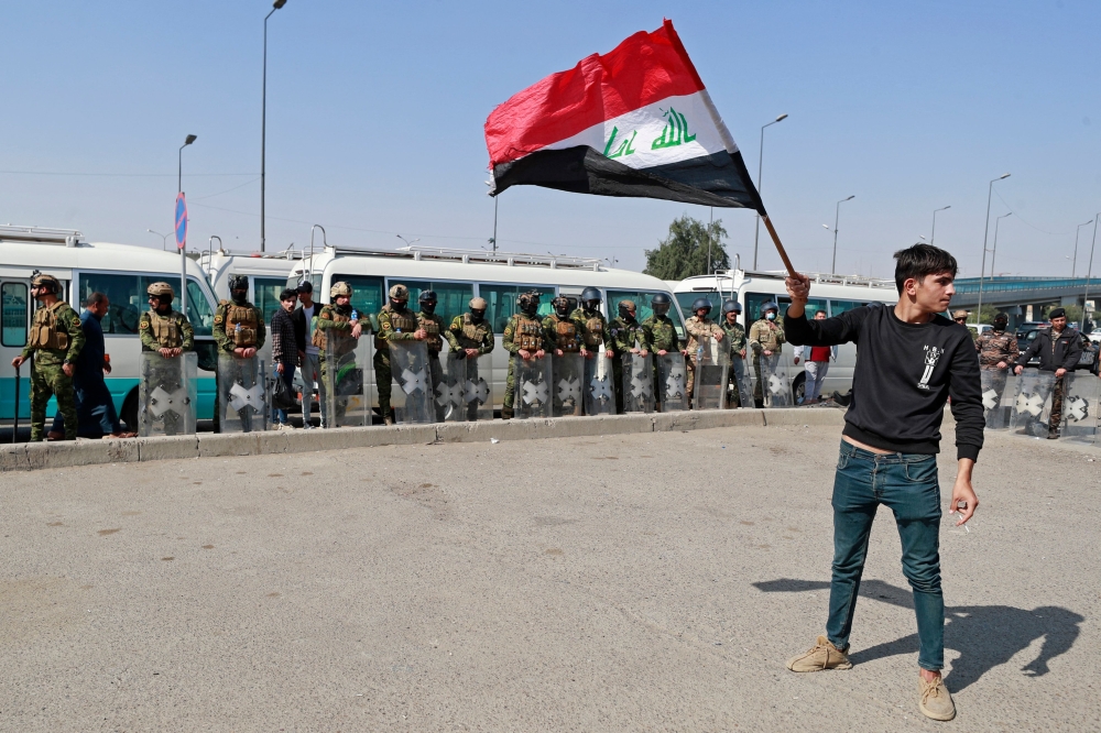 Riot police stand guard during a protest in Baghdad's Green Zone on February 27, 2023 against Iraqi parliament's attempt to amend electoral law. (Photo by AHMAD AL-RUBAYE / AFP)
