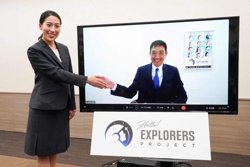 Astronaut candidates for the Japan Aerospace Exploration Agency (JAXA), Ayu Yoneda (L), a surgeon at the Japanese Red Cross Medical Center, and Makoto Suwa (on screen), a disaster prevention specialist at the World Bank, pose after a press conference in Tokyo on February 28, 2023. (Photo by Kazuhiro NOGI / AFP)