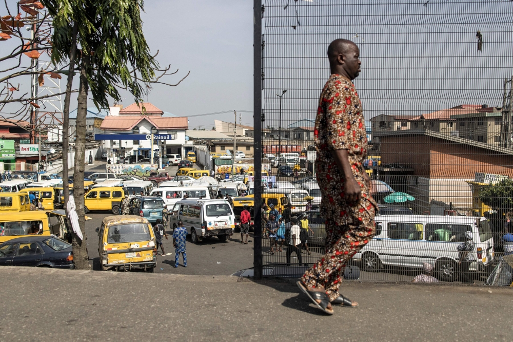 A man walks past a taxi stop in Lagos on February 28, 2023. - Nigerians are waiting for the results of their Presidential elections that where held on February 25, 2023. (Photo by JOHN WESSELS / AFP)