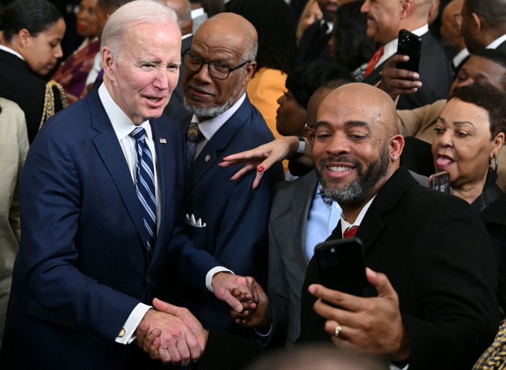 US President Joe Biden takes photos with attendees after speaking at a reception celebrating Black History Month, in the East Room of the White House in Washington, DC, on February 27, 2023. (Photo by SAUL LOEB / AFP)