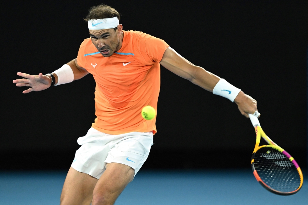 In this file photograph taken on January 18, 2023, Spain's Rafael Nadal hits a return to Mackenzie McDonald of the US during their men's singles match on day three of the Australian Open tennis tournament in Melbourne. (Photo by MANAN VATSYAYANA / AFP) 