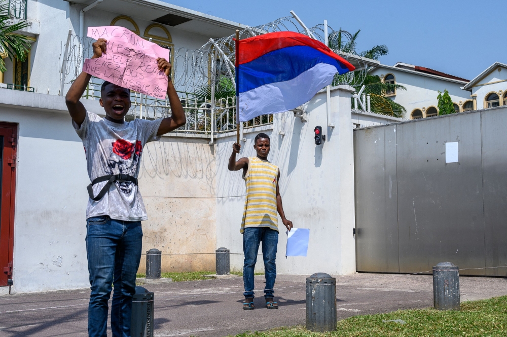 Protesters waving Russian flags gather in front of the French Embassy in Kinshasa on March 1, 2023 for a demonstration against the visit to the Democratic Republic of Congo of French President Emmanuel Macron. The DRC will this week be the last stage of a trip by Emmanuel Macron to Central Africa, which will also take him to Gabon for a summit on the forest, to Angola and to Congo-Brazzaville. - Brandishing Russian flags, a few dozen young Congolese demonstrated in Kinshasa on Wednesday against French President Emmanuel Macron's visit to the DRC, accusing him of supporting Rwanda at the expense of their country. (Photo by Arsene Mpiana / AFP)