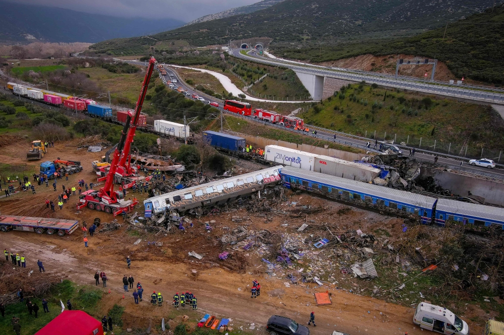 This aerial drone photograph taken on March 1, 2023, shows emergency crews searching wreckage after a train accident in the Tempi Valley near Larissa, Greece. Photo by Vasilis VERVERIDIS / Eurokinissi / AFP
