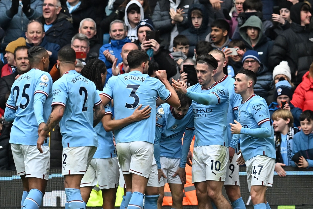 Manchester City's Portuguese midfielder Bernardo Silva (centre) celebrates with teammates after scoring their second goal during the English Premier League football match between Manchester City and Newcastle United at the Etihad Stadium in Manchester, north west England, on March 4, 2023. (Photo by Paul ELLIS / AFP)
