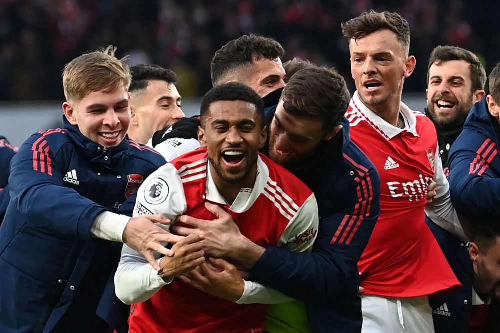 Arsenal's English midfielder Reiss Nelson (center) celebrates after scoring his team third goal of the team during the English Premier League match between Arsenal and Bournemouth at the Emirates Stadium in London on March 4, 2023. (Photo by Glyn KIRK / AFP) 