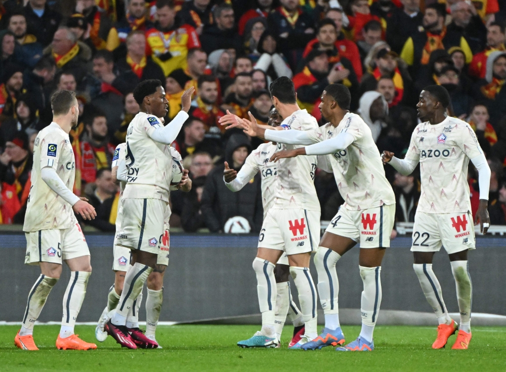 Lille's Canadian forward Jonathan David celebrates with team mates after scoring a goal during the French L1 match between Lens and Lille and the Bollaert-Delelis stadium in Lens on March 4, 2023. (Photo by FRANCOIS LO PRESTI / AFP)
 