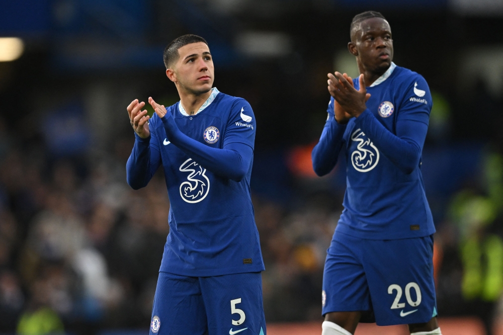 Chelsea's Argentinian midfielder Enzo Fernandez (left) and Chelsea's Swiss midfielder Denis Zakaria (right) applaud supporters on the pitch after the English Premier League match between Chelsea and Leeds United at Stamford Bridge in London on March 4, 2023. - Chelsea won the game 1-0. (Photo by JUSTIN TALLIS / AFP)