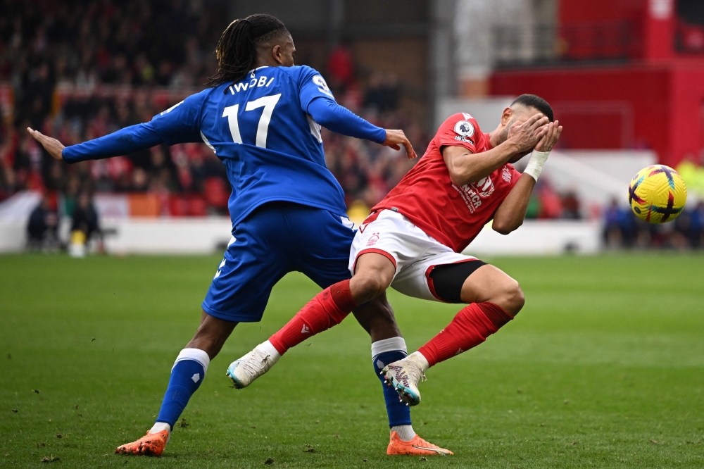 Nottingham Forest's defender Renan Lodi (right) is fouled by Everton's Nigerian midfielder Alex Iwobi during the English Premier League match between Nottingham Forest and Everton at The City Ground in Nottingham, central England, on March 5, 2023. (Photo by Oli SCARFF / AFP)