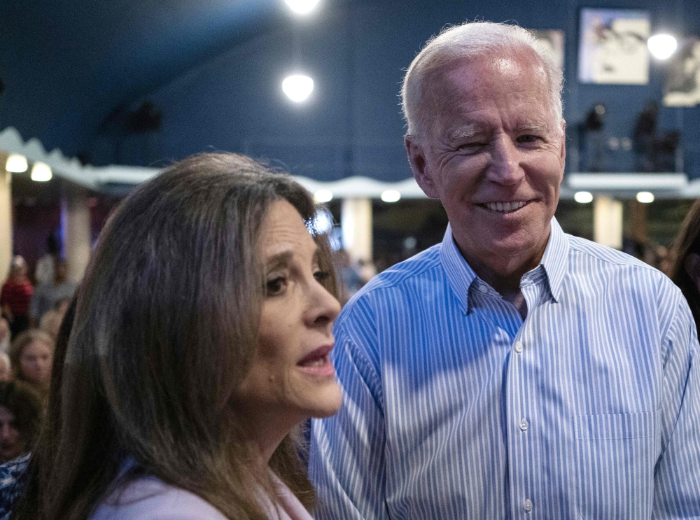 File Photo: Then presidential hopeful Joe Biden talks with fellow candidate Marianne Williamson at the Wing Ding Dinner in Clear Lake, Iowa, August 9, 2019. (Photo by Alex Edelman / AFP)