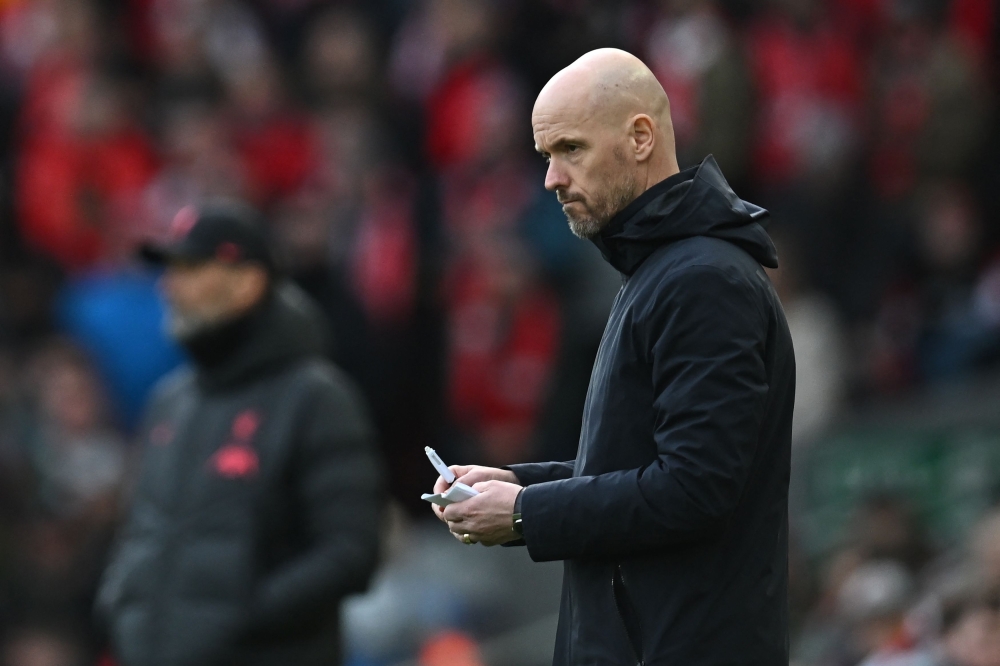 Manchester United's Dutch manager Erik ten Hag makes notes during the English Premier League match between Liverpool and Manchester United at Anfield in Liverpool, north west England on March 5, 2023. (Photo by Paul ELLIS / AFP)